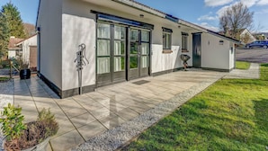 A modern two-story house with a tiled patio, large windows, and a garage. - Holiday Home in Heuvelland With Garden (Heuvelland)