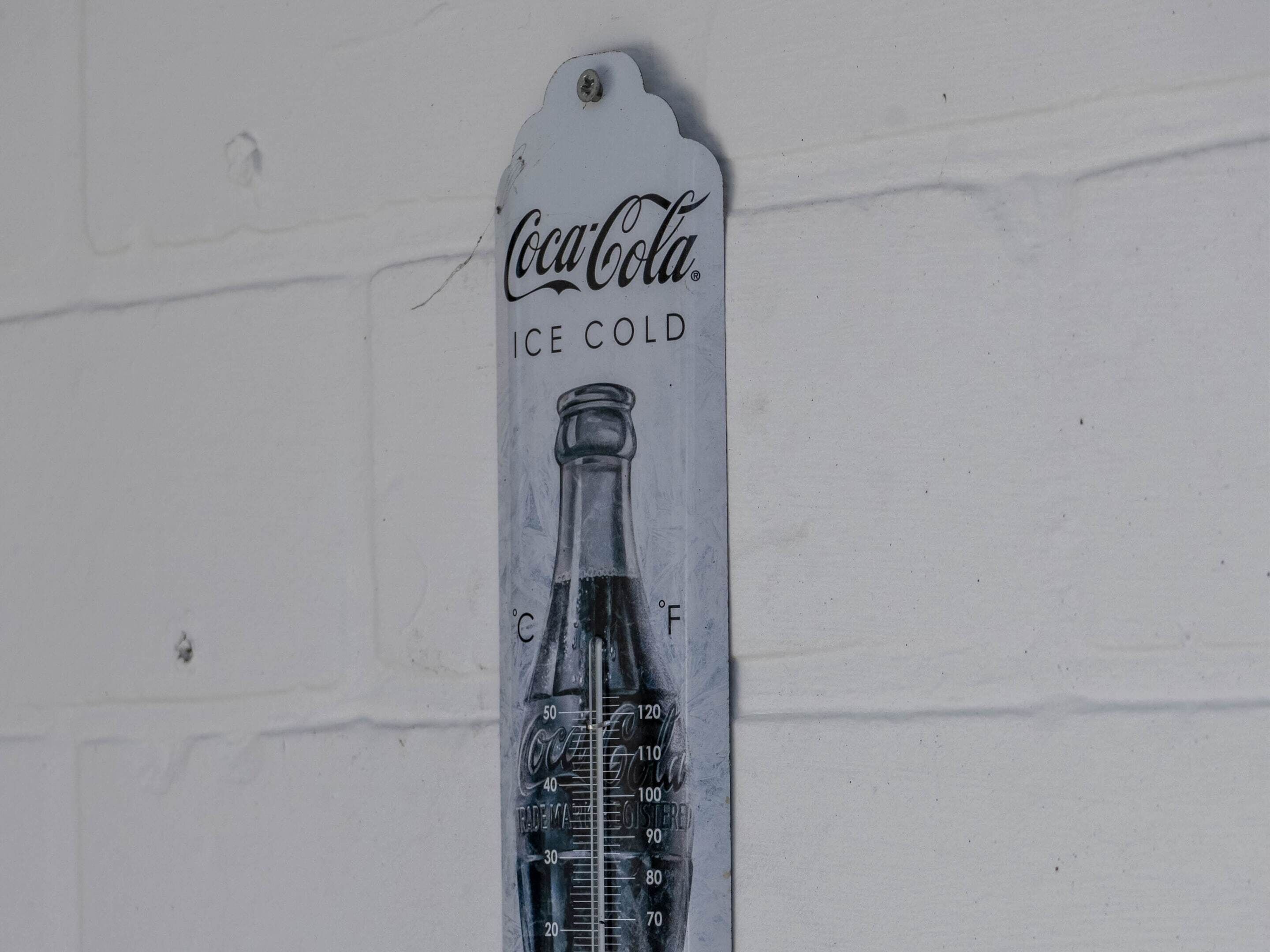 A Coca-Cola branded ice cold bottle with a temperature scale.