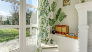 A room with a large window, a white fireplace, and a vintage radio on a shelf. - Holiday Home in Heuvelland With Garden (Heuvelland)