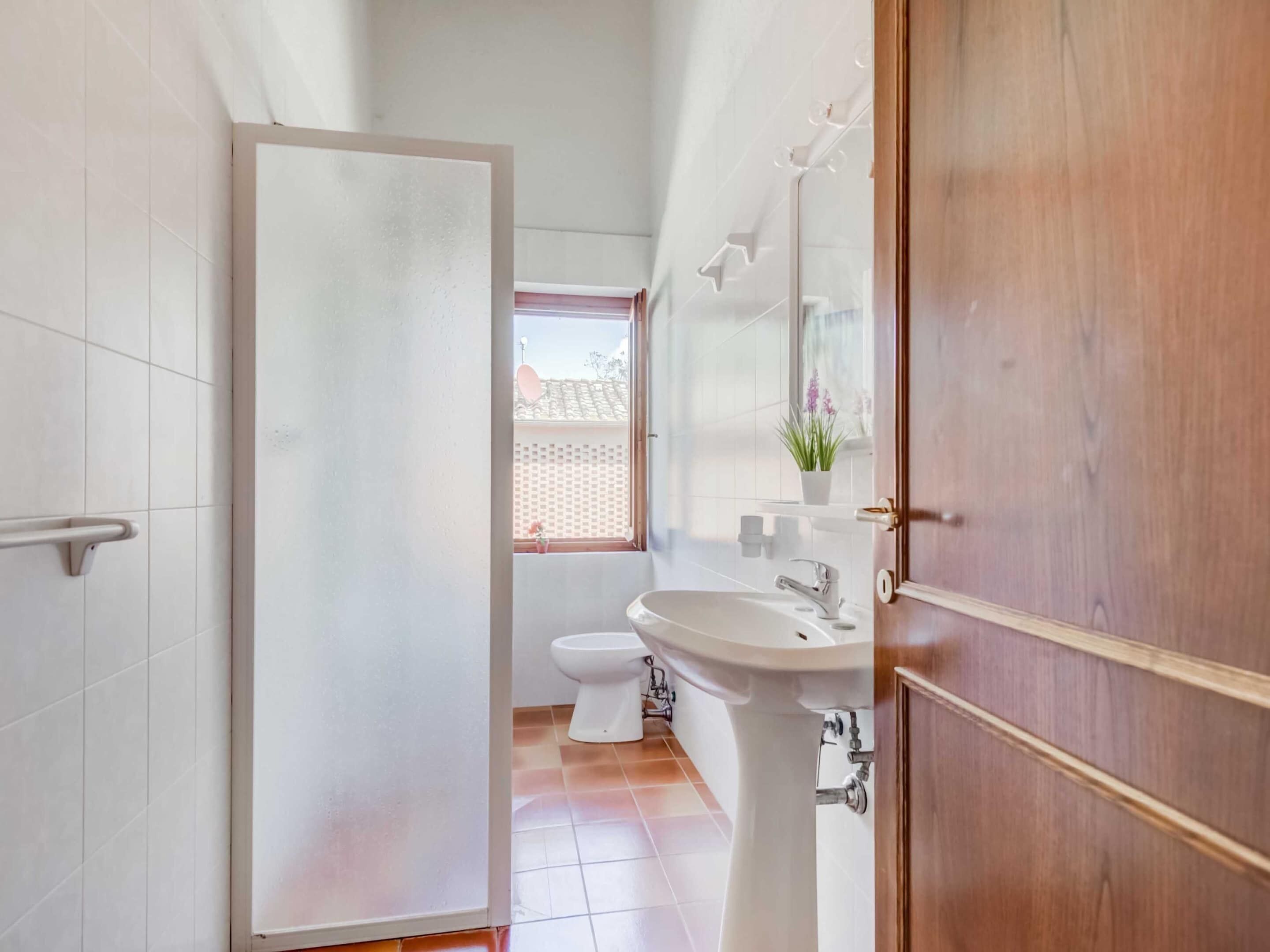 A bathroom with a toilet, sink, and mirror.