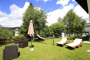 A grassy outdoor area with lounge chairs and a hammock. - Apartment in Seefeld Near Rosshutte (Seefeld in Tirol)