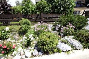 A garden with various plants, rocks, and a wooden fence. - Apartment in Seefeld Near Rosshutte (Seefeld in Tirol)