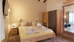 Une chambre d’hôtel avec un lit, des tables de chevet, une télévision et une armoire.