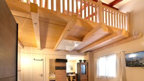 A hotel room with a wooden ceiling, a bed, a desk, and a wardrobe. - Apartment in Seefeld Near Rosshutte (Seefeld in Tirol)