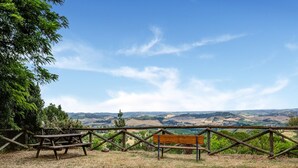 A picnic area with a bench and table, surrounded by a wooden fence, overlooking a scenic landscape with rolling hills and a clear sky. - Varna Charm: Tuscan Getaway (Gambassi Terme)
