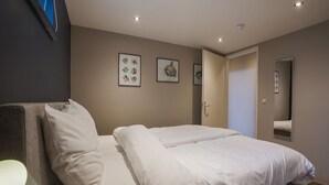 A modern bedroom with a large bed, a bedside table, and a lamp. - Scenic Escape With Garden (Grubbenvorst)