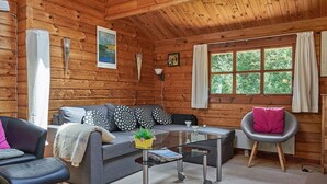 A cozy cabin interior with a sofa, armchair, and a small table with a plant. - 6 Person Holiday Home in Hurup Thy (Hurup Thy)