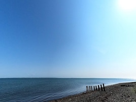 Una playa con cielo despejado y mar tranquilo.