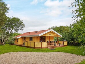 A yellow wooden house with a red roof, a covered porch, and a gravel driveway. - 6 Person Holiday Home in Hurup Thy (Hurup Thy)