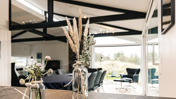 A modern interior with a marble table displaying two glass vases with dried plants. - Holiday Home in Saltum (Saltum)