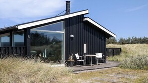 A modern black building with large windows and a deck area. - Holiday Home in Saltum (Saltum)