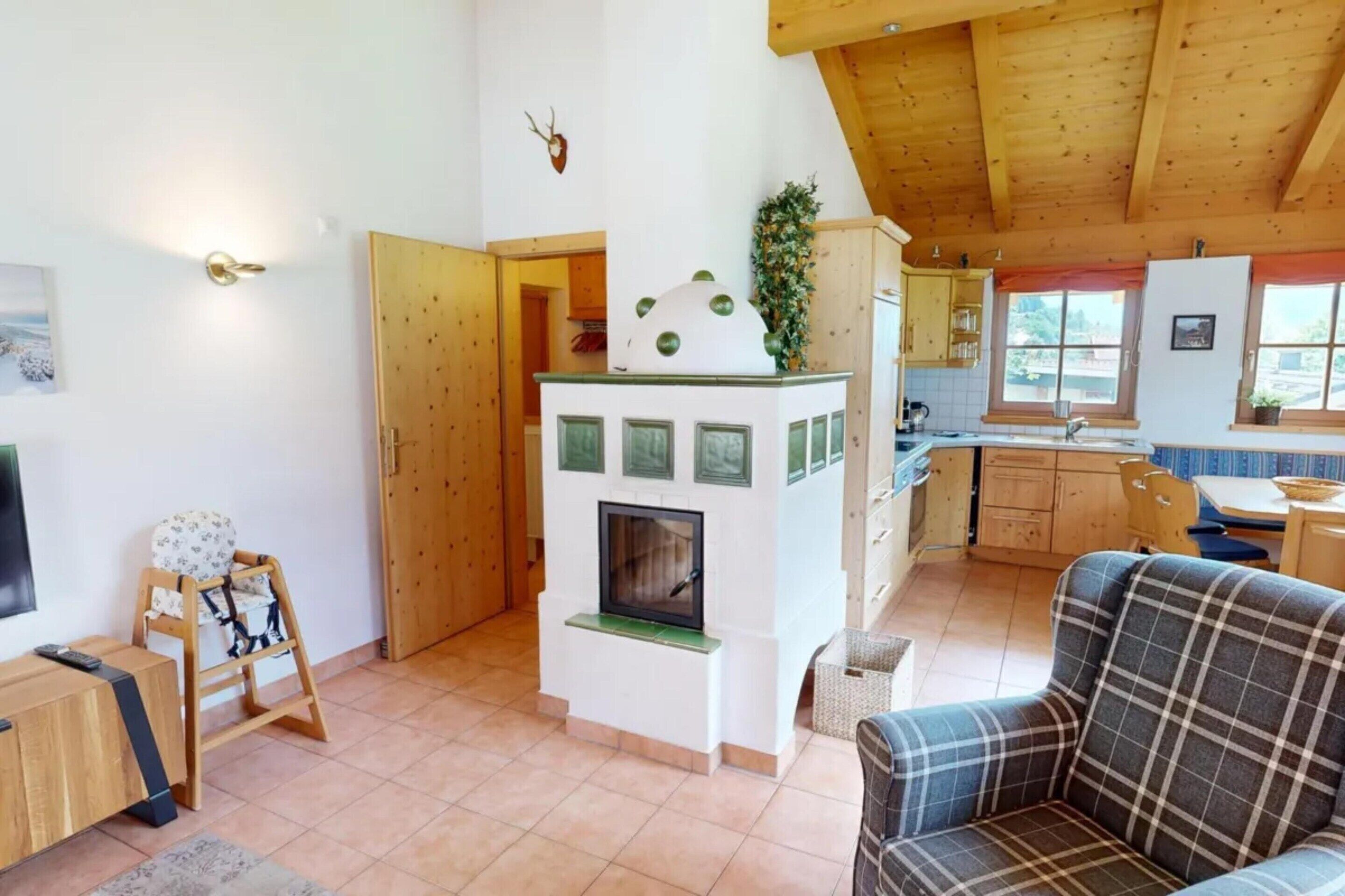 A cozy living room with a fireplace, a dining area, and a kitchen with wooden cabinets.