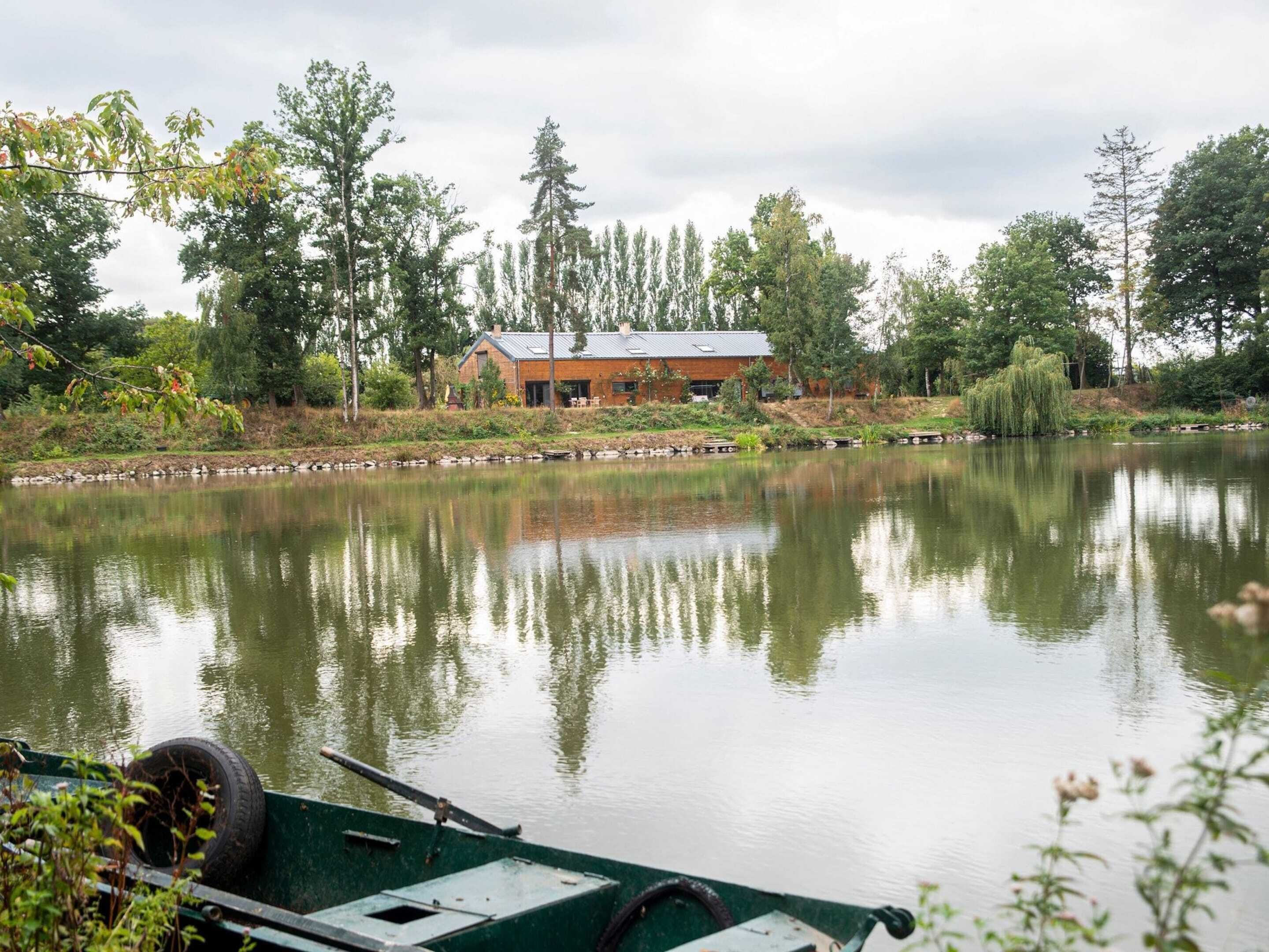 Propiedad frente al lago con casa, muelle y agua tranquila que refleja el entorno.