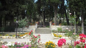 A garden with a stone pathway leading to a staircase surrounded by various flowering plants. - Rustic Elegance Near Florence (Rignano sull'Arno)