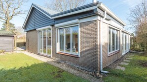 A modern house with a brick exterior, large windows, and a chimney. - Attractive House with Sunny Garden near Veerse Meer (Kortgene)