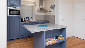 A compact kitchen with a built-in oven, a gas stove, and a stainless steel range hood. - Attractive House with Sunny Garden near Veerse Meer (Kortgene)