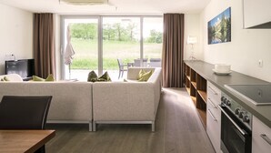 A modern hotel room with a sofa, dining table, and kitchenette. - Alluring Apartment in Höggen near Ski Slopes with Sauna (Radstadt)