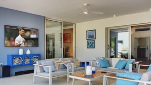 A modern living room with a flat-screen TV, comfortable seating, and a dining area. - Villa in Stinjan With Pool and Sea View (Pula)