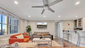 A modern living room with a sofa, coffee table, and a ceiling fan. - Downtown retreat on iconic Peachtree w/ balcony (Atlanta)