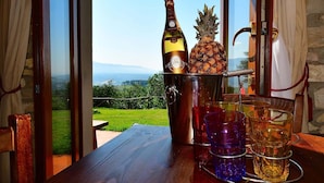 A wooden table with a bottle of wine, a pineapple, and glasses. - Apartment With Pool, Rignano (Rignano sull'Arno)