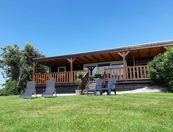 A lodge with a covered porch, outdoor seating, and a staircase leading to the entrance. - Cottage in Paesens Near Wadden Sea (Paesens)