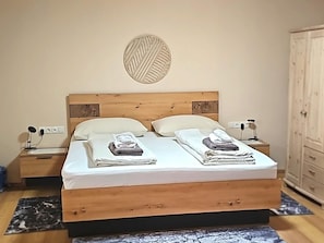 A bed with a wooden headboard, two bedside tables, a wall-mounted light fixture, and a wardrobe. - Country House in Seefeld Near Ski Resort (Seefeld in Tirol)