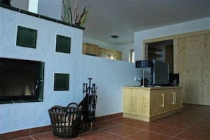 A living room with a TV, wooden cabinets, and a tiled floor. - Tranquil Mountain Chalet for 8 (Wald im Pinzgau)