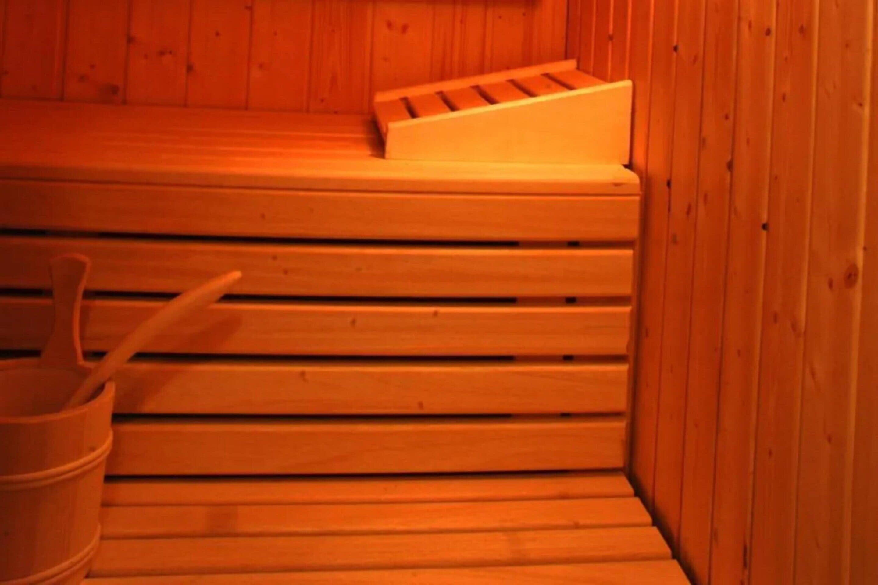 A sauna with wooden benches and a bucket.