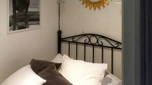A bed with white and brown pillows, a black metal headboard, a wall-mounted mirror, and a poster on the wall. - 5 Person Holiday Home in Sarna (Sarna)