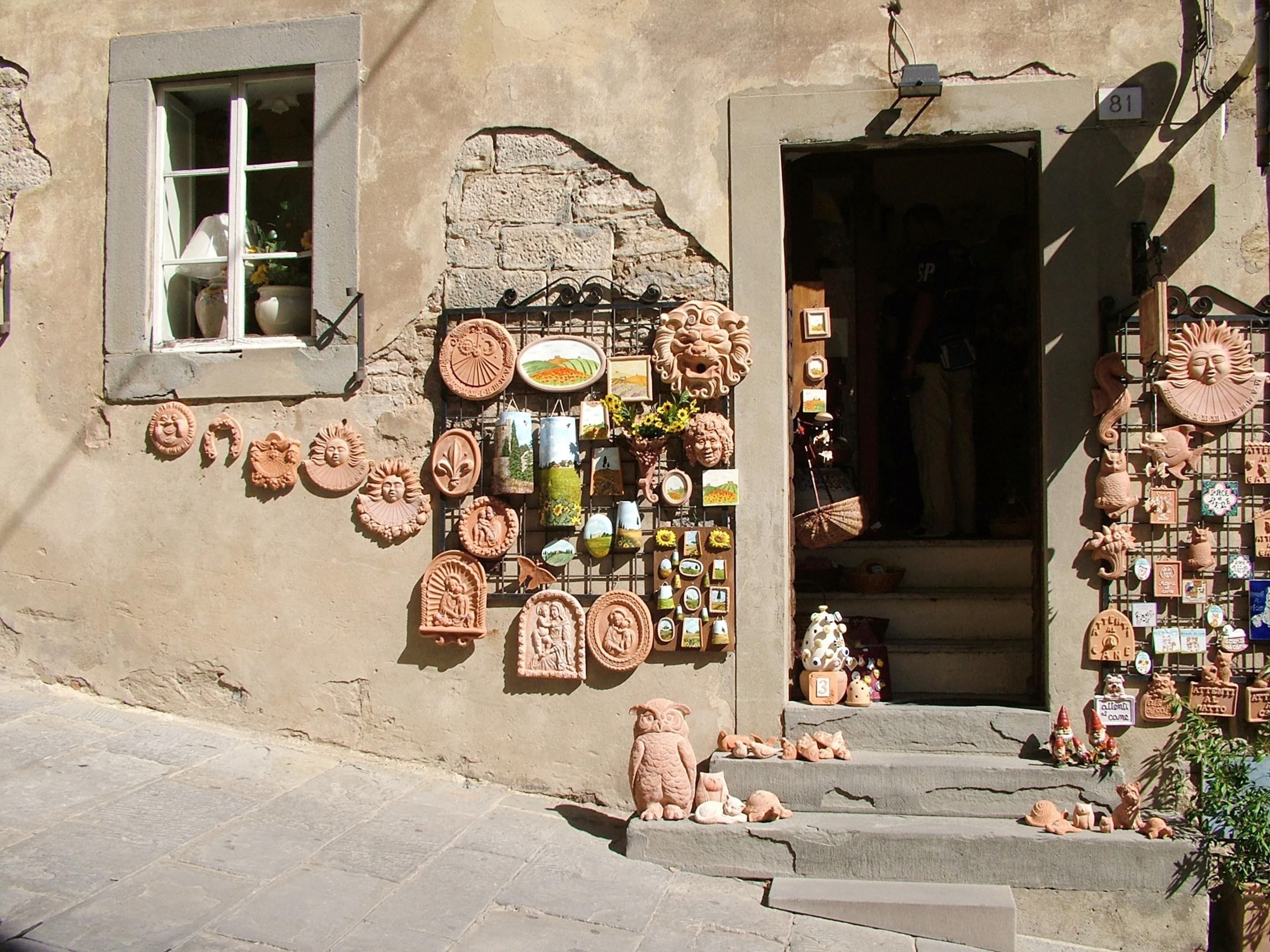 Edifici amb façana de pedra, finestra amb vistes i diversos objectes de ceràmica exposats a l'exterior.
