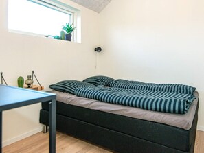 A small, single-bed room with a window, a bedside table, and a lamp. - Holiday Home in Tarm (Tarm)