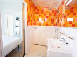 A modern bathroom with a shower, a sink, and a bed. - Wheelchair-friendly Retreat (Callantsoog)