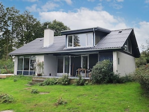 A modern two-story house with a large front porch, a chimney, and a well-maintained lawn. - 6 Person Holiday Home in Roslev (Roslev)