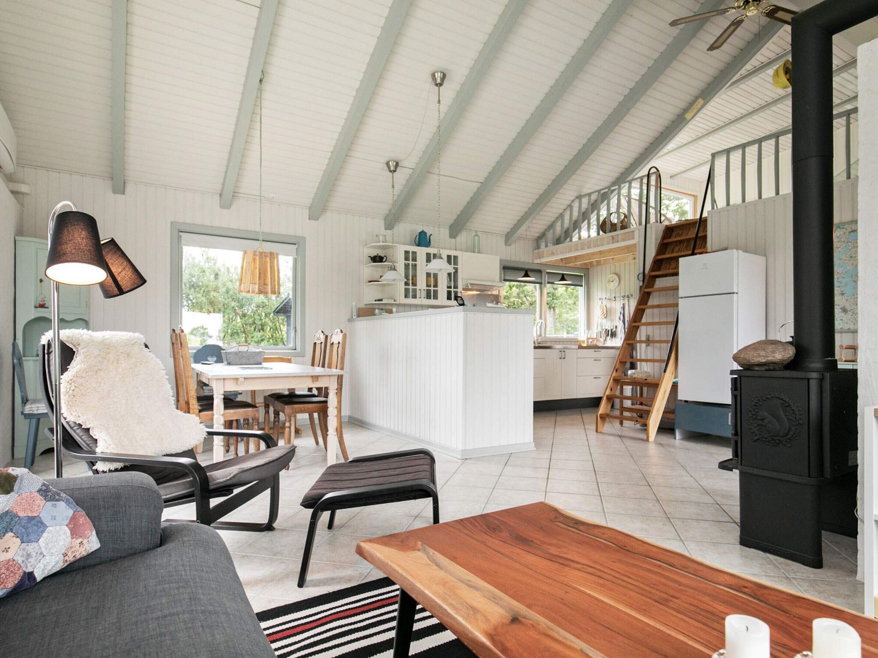 A spacious kitchen with a central island, wooden furniture, and a black stove.