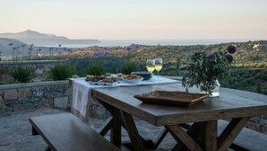 An outdoor dining table with a view of a mountainous landscape.
