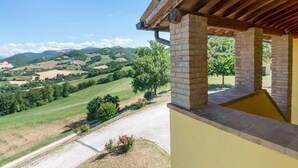A covered outdoor area with a view of rolling hills and a clear sky. - Holiday Home in Urbania With Hill Views (Urbania)