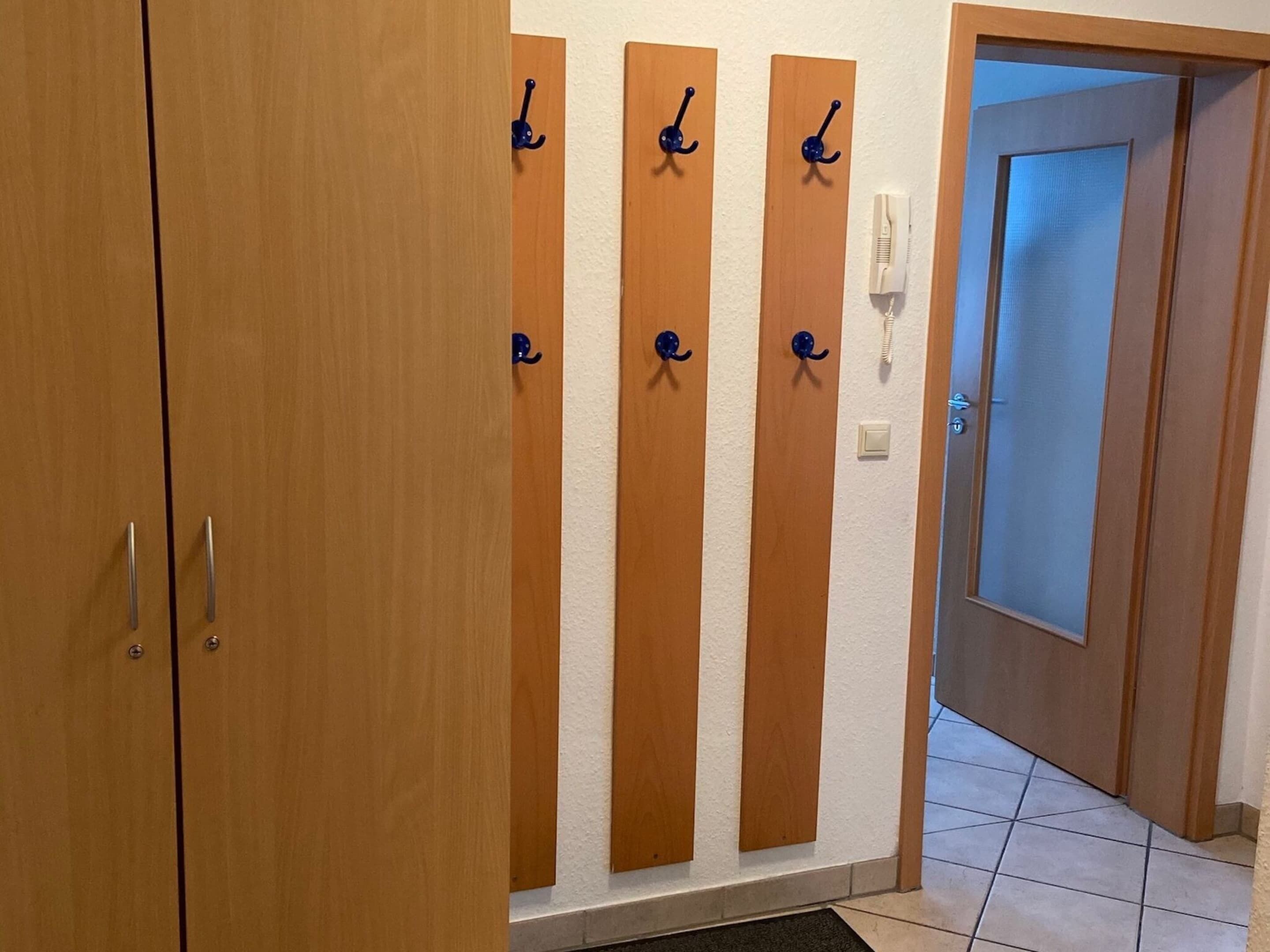 Ein Flur mit Holztüren und einem Kleiderständer.