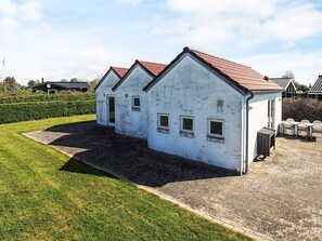 A white building with a red roof, a gravel driveway, and a well-maintained lawn. - 6 Person Holiday Home in Karrebaeksminde (Karrebæksminde)