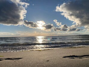 A beach with waves, a clear sky, and sunlight reflecting on the water. - 6 Person Holiday Home in Karrebaeksminde (Karrebæksminde)
