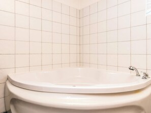 A bathroom with a freestanding bathtub, a toilet, and tiled walls. - 6 Person Holiday Home in Karrebaeksminde (Karrebæksminde)