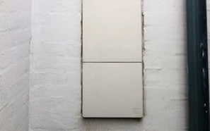 A wall-mounted light switch on a textured wall.