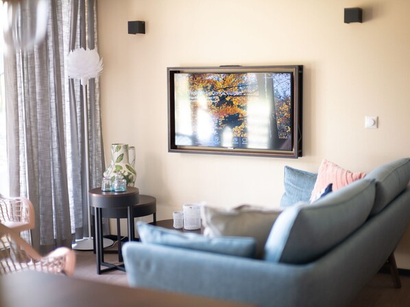 A living room with a sofa, a coffee table, a small side table, and a framed artwork on the wall. - Special Hillside Lodge, Near Maastricht (Gulpen)