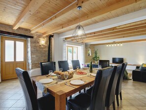 Un coin repas avec une table en bois dressée pour six personnes, entourée de chaises noires.