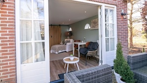 A cozy room with a bed, a small table, and a chair. - Holiday Home in Medemblik With Garden (Medemblik)