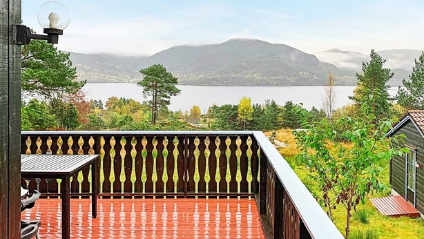 A balcony with a view of a lake and mountains. - 6 Person Holiday Home in Ostereidet (Alver)