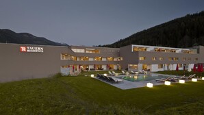 Ein modernes Hotel mit Pool, Außenbereich und Bergblick.
