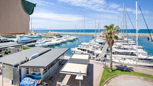 A marina with numerous boats docked, a building with a covered area, and a clear view of the sea. - Holiday Gome in San Vincenzo Near Beach (San Vincenzo)