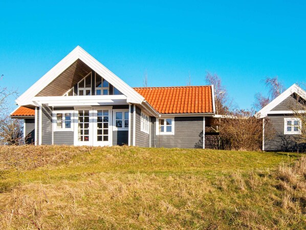 A two-story house with a sloped roof and a large front porch.