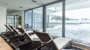 A modern room with large windows, a seating area with chairs, and a view of snow outside. - Nice Apartment With Dishwasher, Near the Ski Slopes (Radstadt)