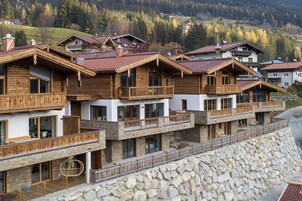 Una hilera de edificios de estilo chalé de madera con balcones, con montañas al fondo.